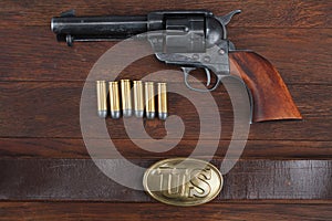 Old revolver with cartridges and U.S. Army soldier& x27;s belt with a buckle