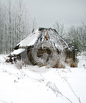 An old crumbling hut in the winter forest