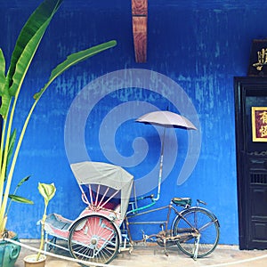 Old Rickshaw in front of Blue house