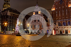 Old Riga the capital of Latvia at night. House of Blackheads in the Town Hall Square and the spire of the Cathedral in the