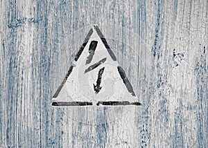 Old risk of electric shock triangle sign on light grey weathered cracked background