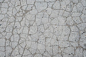 Old road background - surface of grey cracked asphalt texture