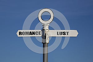 Old road sign with romance and lust pointing in opposite directions