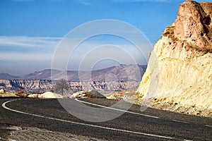 Old road and strange landscape with a valley, mountains and blue sky in a sunny day. Landscape in Cappadocia in Turkey