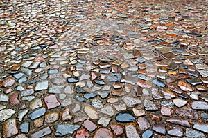 The old roadway of granite cobblestone. Wet road