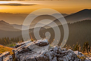 Old rock with sunrise over mountain ranges