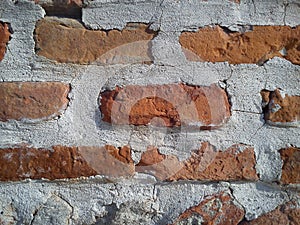 Old roman brick. The restored wall of the building of the Roman conquerors. Warm brown-red shades of uneven bricks. Archaeological