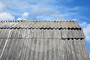 Old roof asbestos roof slates against blue sky