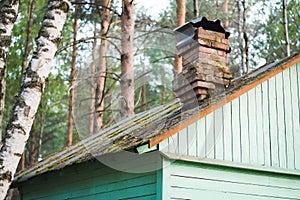 Old roof with chimbley on the hut in the woods photo