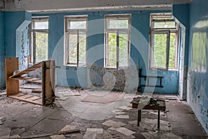 Old room with broken windows and tables at the abandoned building in the Chernobyl ghost town