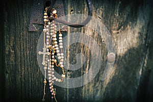Old rosary against ancient wooden background. Horisontal image