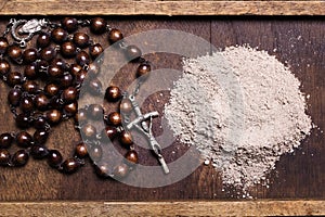 Old rosary and ash - symbols of Ash Wednesday.