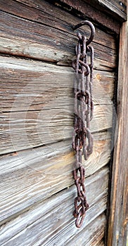 Old rosty chain on a barn wall