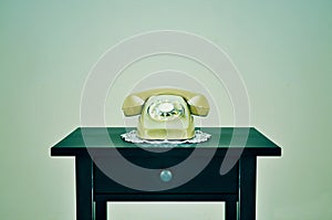 Old rotary dial telephone on a table, with a retro effect