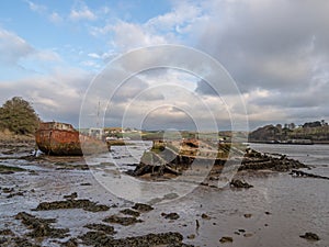 Old, rotting boats, wrecks on the mud flats. River Torridge Estuary near Appledore in north Devon, England, UK.