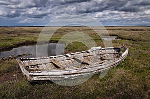 Old rotting wooden stranded rowing boat