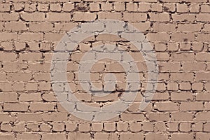 Old rough dirty exterior brick wall texture. Beige shabby messy brickwork. Light brown grunge background