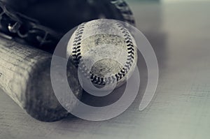 Old rough and rugged baseball and vintage wooden bat on blue texture background.