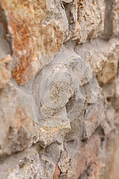 Old rough stone wall with weathered abstract cracked texture