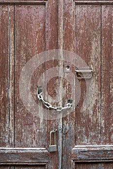 Old rough wooden door with bolts and padlocks