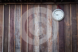 Old round clock hang on old wooden wall