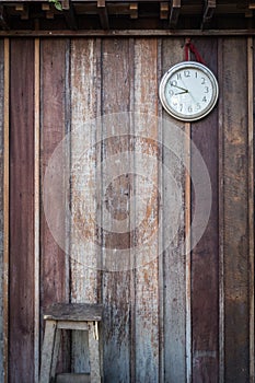 Old round clock hang on old wooden wall