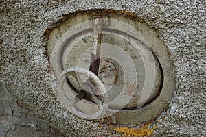 Old round rusty tank faucet close-up outdoors, side view