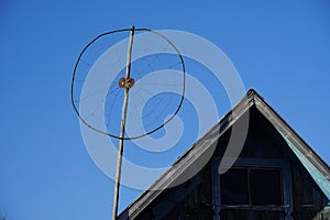 old round wire analog antenna. homemade. on old wooden house building village