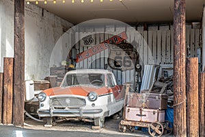 Old route 66 signs with rusty old car in garrage USA