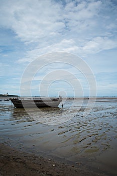 An old rowing boat in need of repair on the beach