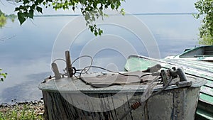 Old rowing fishing boats are tied and marooned with chains to the river shore.