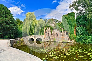 Old ruin called `Kirchenruine zum heiligen Grab` in front of pond in public park called `SchÃ¶ntal` in German city Aschaffenburg