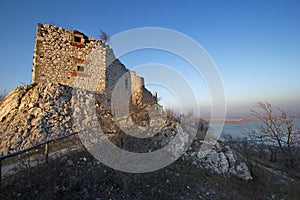 Old ruin castle above the level of the lake in sunset time, Devicky, Moravia, Czech republic