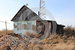 Old ruined house in the village in a dirty fence uninhabited abandoned building