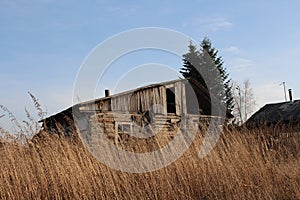 Old ruined house in the village in a dirty fence uninhabited abandoned building