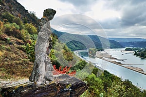 Old ruined statue of a man with grapes standing on a hill of Hesse land at the river Raine, Germany