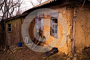 Old ruined village house. Window frame, broken glass, peeling paint.