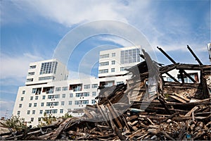 Old ruined wooden house on the background of the new buildings