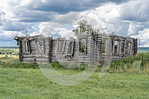 An old ruined wooden house of five walls made of pine logs for demolition is located in a beautiful natural place with clean air