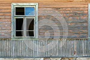 An old ruined wooden house in the village. Details of the facade of a historic wooden house with carved shutters and vintage decor