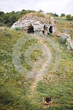 Old ruins of Skala Podilskyi castle, Ukraine. Destroyed ruined stone walls of medieval castle and green grass, historical defence