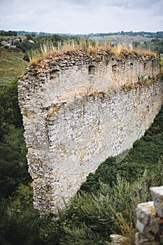 Old ruins of Skala Podilskyi castle, Ukraine. Destroyed ruined stone walls of medieval castle and green grass, historical defence