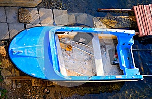 Old run-down abandoned blue boat on the shore.