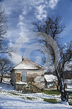 Old rural house covered with snow at a village