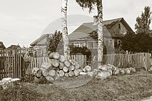 Old rural house with pile of big wooden chocks in front