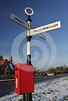 Old rural road sign, with postbox