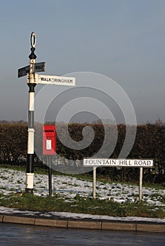 Old rural road sign, with postbox