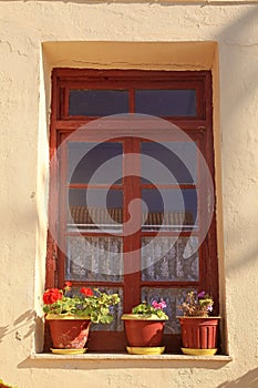 Old rural window with flower pots, Crete, Greece.