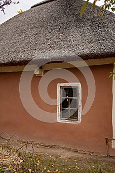 Old rural wooden house with thatched roof. Fall season. Close-up