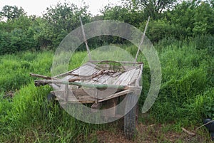 Old Russian carriage against the background of green grass. Cart. Dray.